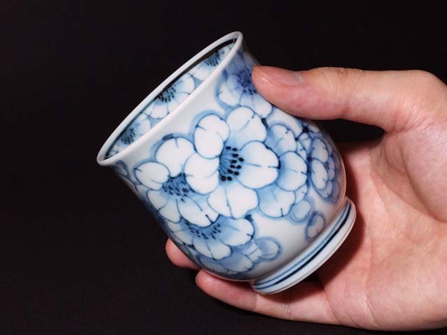 有田焼 湯呑み 染付王冠桜。藍一色の牡丹を描いた湯呑を手に持ったところ